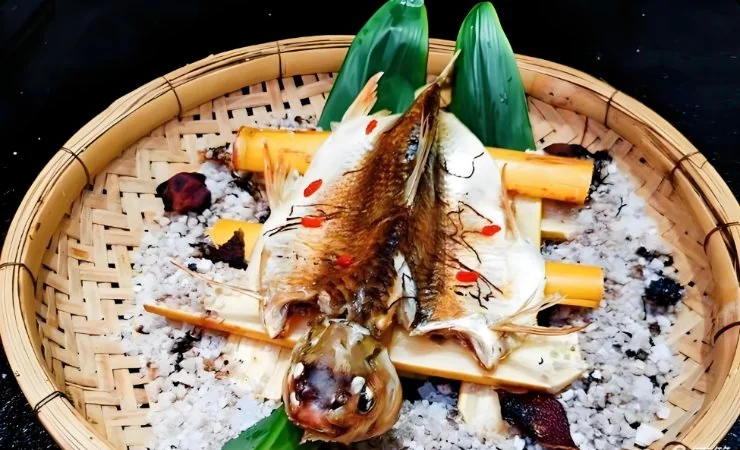 茶蔗熏鲮鱼成菜:鱼身外皮微焦、内里鲜嫩,盛于竹匾之中