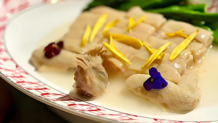 江南百花鸡成菜：鸡件呈日字形摆盘，鸡头鸡尾配对复原整鸡形态，撒上夜来香花瓣