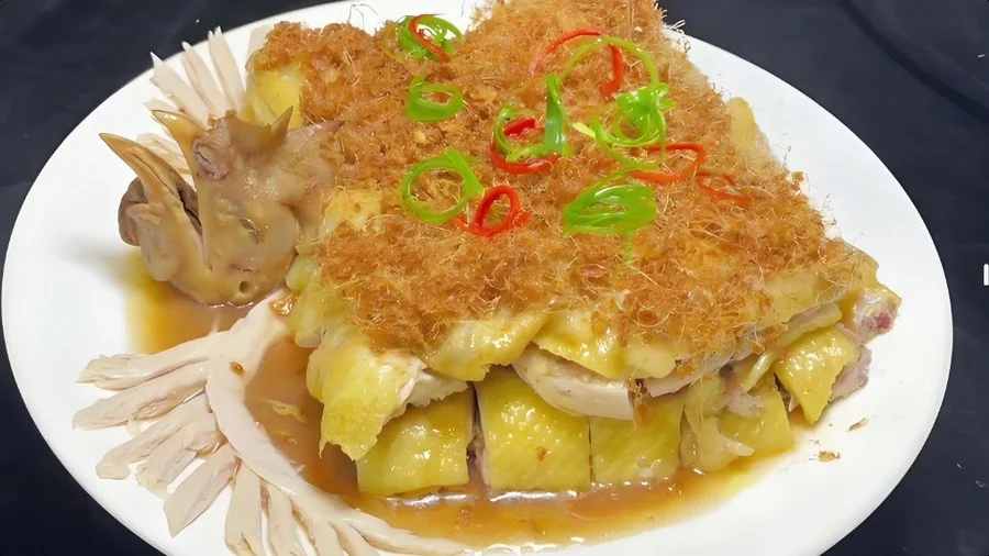姜茸鸡成菜:鸡件齐整码盘,面上铺一层金黄蓬松的炸姜茸,青红椒圈点缀,盘底一汪豉油汁