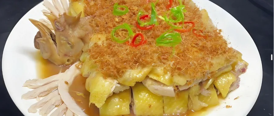 姜茸鸡成菜：鸡件齐整码盘，面上铺一层金黄蓬松的炸姜茸，青红椒圈点缀，盘底一汪豉油汁
