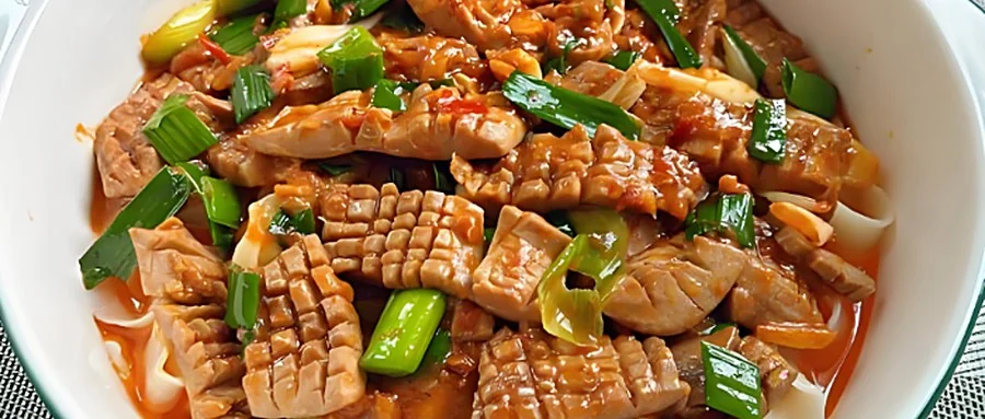 一碗爆炒猪腰面：腰花切成麦穗花刀、裹浓郁红亮芡汁，铺在面上，撒青葱段