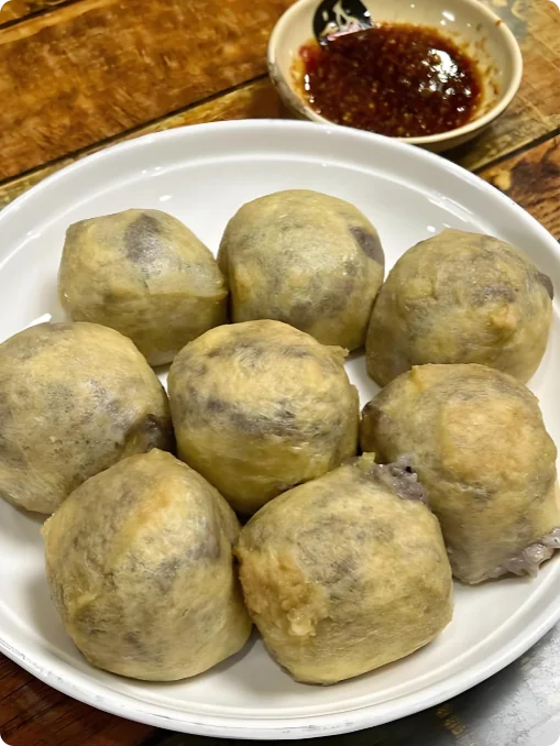 一盘酿豆腐，油豆腐塞肉饱满圆润，旁配一小碟辣椒酱